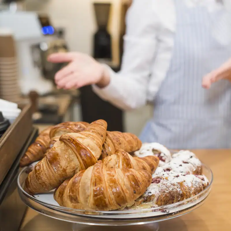 Čerstvé malované croissanty na talíři, ručně zdobené a pečlivě připravené.